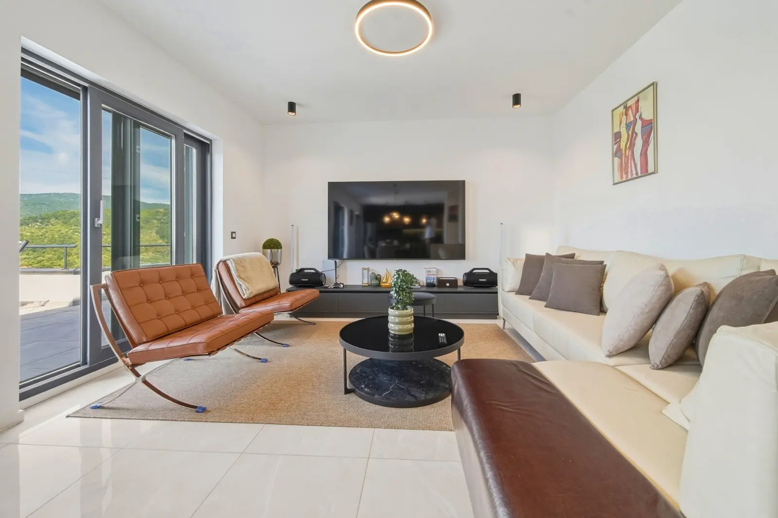 Living room with Barcelona chairs and large TV at Villa Medvednica